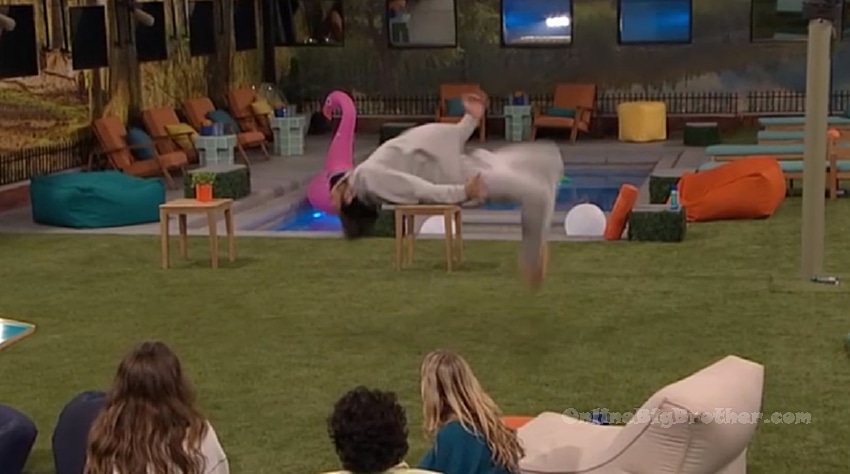 Kamu doing a back flip in the Big Brother backyard while houseguests watch