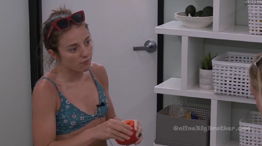 Melody talking with Mallory in the Big Brother house at 2:33 PM, holding a piece of fruit during their strategy conversation