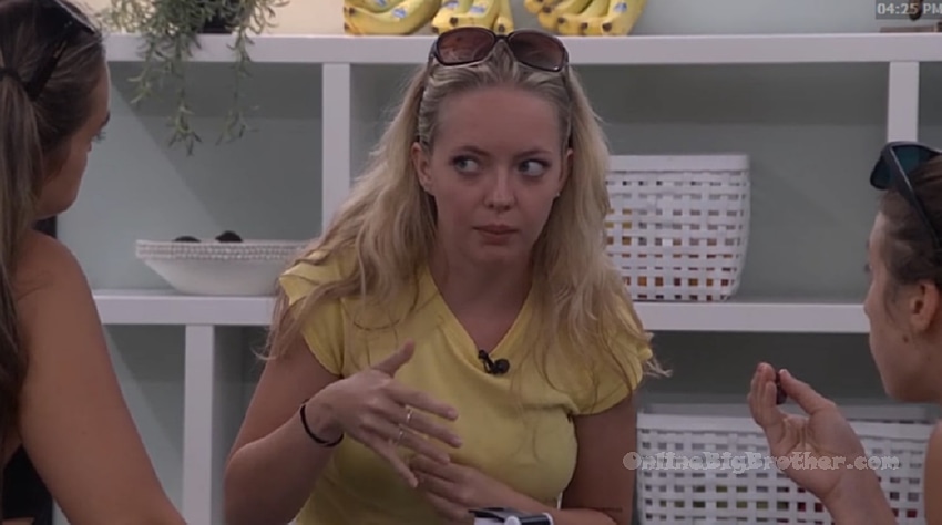 Melody gestures while talking to Mallory and Lyric in the storage room during their 4:25 PM conversation