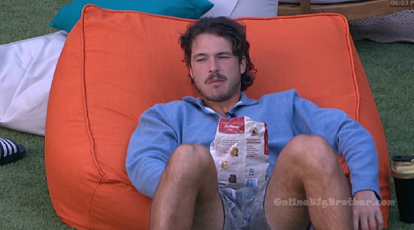 A houseguest relaxes on an orange bean bag chair outside, snacking from a bag of Archway cookies around 6 PM