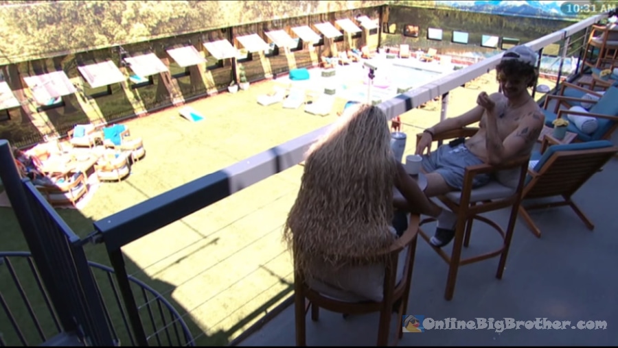 Taylor and Barrett talking on the Big Brother backyard balcony overlooking the pool area at 10:31 AM