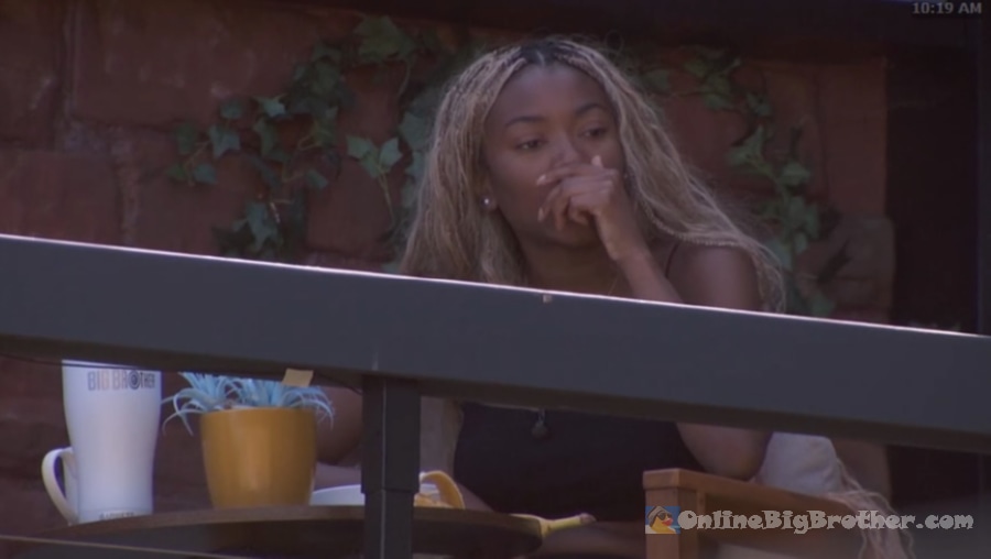 Taylor sitting alone outside at 10:19 AM, hand over her mouth, looking contemplative