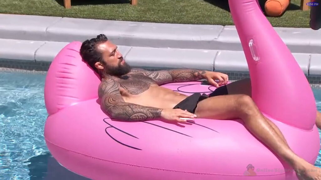 Kamu laying on a giant pink flamingo in the backyard swimming pool